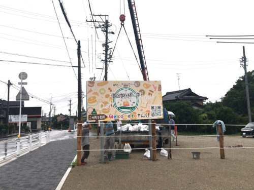 自立看板施工事例写真 愛知県 完成した看板をクレーン車で吊り看板を建て、コンクリートを穴に流し込み転びを調整しながら足元を固めていきます